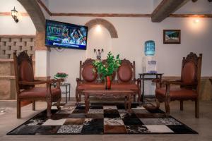 莱瓦镇Hospederia Flor de la Villa Real的客厅配有两把椅子和电视