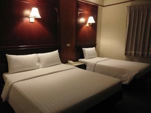 曼谷MIDO Hotel的酒店客房设有两张床和电话