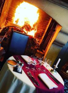 贝莱姆瑞莱斯圣路易斯，罗吉思酒店的餐桌上配有酒杯和壁炉的桌子