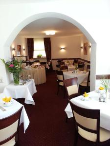 汉诺威豪斯斯帕库勒伽尼酒店的一间设有白色桌椅的用餐室
