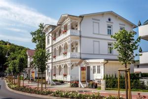 宾茨加尔尼艾卡酒店的白色的建筑,在街上有白色的修剪