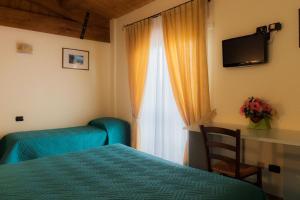 MonterubbianoVilla Montotto的一间卧室设有一张床和一个带电视的窗户。