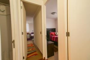 圣地亚哥Apartamento hogareño的走廊通往带红色沙发的客厅