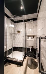 剑桥华特曼酒店的一间带玻璃淋浴和卫生间的浴室
