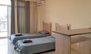 卡瓦拉提Sunset Kvariati Sea Home的客房设有两张床、一张桌子和一扇窗户。