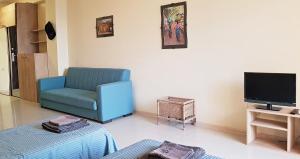 卡瓦拉提Sunset Kvariati Sea Home的客厅配有蓝色椅子和电视