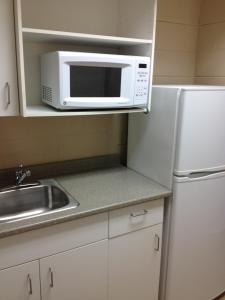 萨德伯里北萨德伯里公寓及会议中心的厨房配有白色冰箱和微波炉