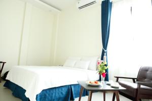 海防Noblesse Hotel的一间卧室配有一张床、一张桌子和一张沙发