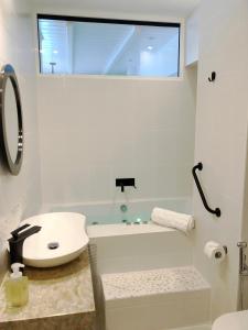 新阿尔塔基Colours Seaview Apartment的白色的浴室设有水槽和浴缸。