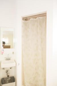 洛杉矶橙色驱动旅舍的浴室配有淋浴帘和盥洗盆。
