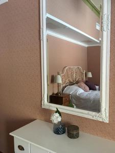 萨翁林纳Cafe-Restaurant & Hotel Saima的墙上的镜子,房间里的床