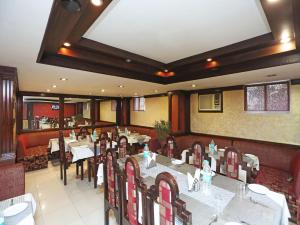 古瓦哈提Hotel Amrit Regency的一间在房间内配有桌椅的餐厅
