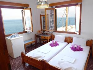 阿基欧斯尼古拉斯玛洛斯旅馆的一间带两张床的卧室,享有海景