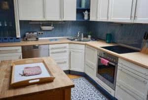 韦斯特兰Alter Konsumverein App N°9的厨房配有白色橱柜和柜台上的切板