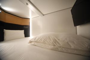 东京多美迎后乐园酒店的客房内的白色床和白色枕头