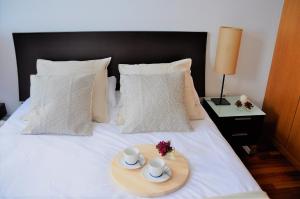 圣克鲁斯-德特内里费Apartamento Torre1的床上装有两个杯子和两个杯子的托盘
