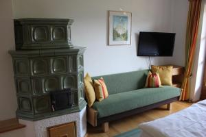 湖滨福煦Haus Klaushofer的客厅配有绿色沙发和电视