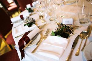 卡伦德罗马营乡间别墅酒店的一张桌子上放有白色餐巾和银器