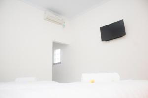 珀尼达岛Miko Bali Bungalow的一间白色墙壁上配有平面电视的房间