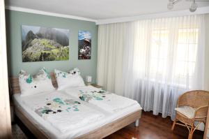 Leiben瓦豪旅馆的一间卧室配有一张带白色床单的大床