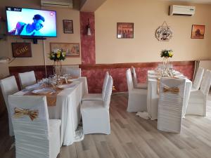德罗贝塔-塞维林堡Mon Cheri的一间配备有白色桌椅和电视的用餐室