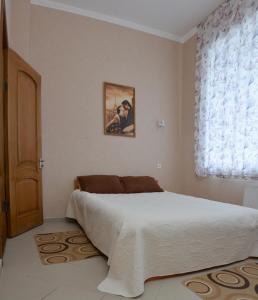 尼古拉耶夫卡拉维拉酒店的一间卧室设有一张大床和一个窗户。