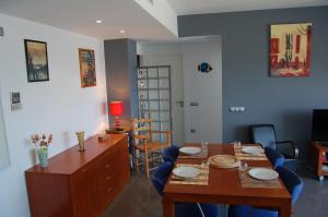 拉梅特拉·德·玛尔Vistas al mar的一间带木桌和蓝色椅子的用餐室
