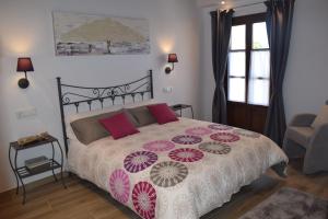 比利亚维西奥萨L'Arbolea de Rodiles的卧室配有一张带红色和粉红色枕头的大床