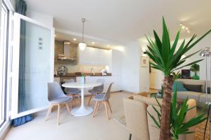 马拉加La Tierra Sur apartment Malaga Center的客厅以及带桌椅的厨房。