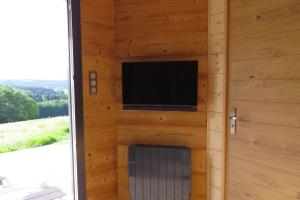 AnouldNature Cottage Vosges的木墙上的平面电视,设有门