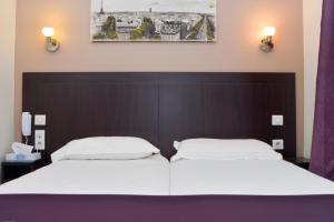 巴黎塞纳码头酒店的配有白色床单的酒店客房内的两张床