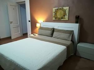卡塞勒托瑞尼斯Le ginestre的卧室配有白色大床和灯