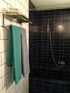 Ubbergen可蒙住宿加早餐旅馆的浴室铺有蓝色瓷砖,提供绿色毛巾。