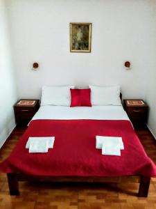 斯韦蒂·斯特凡欧阿扎旅馆的一间卧室配有一张带红色毯子的床