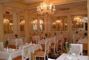 威尼斯贝里埃波科酒店的餐厅配有白色的桌椅和吊灯