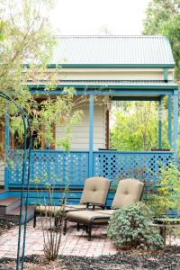 莫尔登Parker Lodge Maldon的庭院设有两把椅子和蓝色的围栏