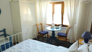 PisanoB&B Mamma Mia的一间卧室配有桌子、两把椅子和窗户
