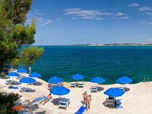 波雷奇Lanterna Resort的海滩上有人,海滩上有人,海滩上有人,海滩上有人,海滩上有人,海滩上有人,蓝色伞
