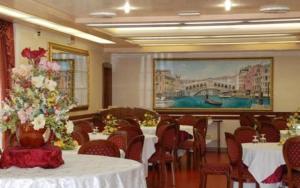 米拉伊尔博其罗酒店的用餐室配有桌椅和鲜花