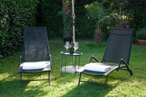 波尔托罗Casa Rossa Apartment的草地上的两把椅子和一张桌子