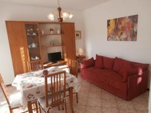 格拉多Agata Apartments的客厅配有红色的沙发和桌子