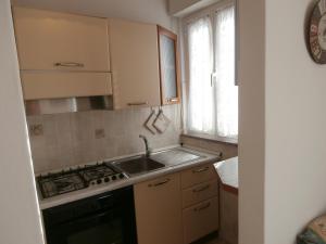 格拉多Agata Apartments的厨房配有水槽、炉灶和窗户。