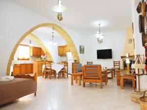 RodhopósTraditional Cretan Villa的客厅设有拱门、桌子和椅子