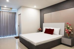 曼谷DB Plus 5的卧室配有白色的床和红色枕头