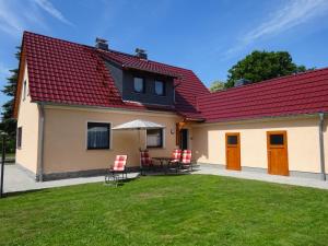MalschwitzFerienhaus Oberlausitz的一座带红色屋顶、桌子和椅子的房子