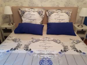 帕尔兹哈克Villa SAINT-PRIVAT的一张带蓝色和白色床单及枕头的床