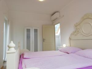 鲍洛通费尼韦什Fenyves Ferienhaus 1 ****的白色卧室配有白色床和紫色床单