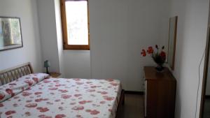 圣卡塔尔多BILOCALE 4 posti a campoverdevillage的一间卧室,配有一张床和花瓶