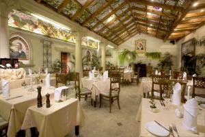 布拉格绿花园酒店的餐厅设有白色的桌椅和天花板