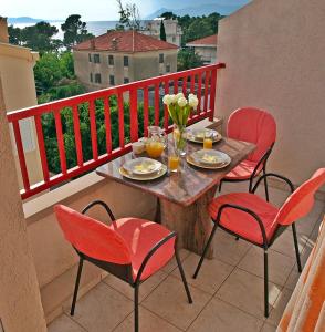 马卡尔斯卡Apartment Andromeda sea view的阳台配有桌子和四把椅子,